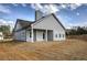 A gray home showcasing a covered porch, white trim windows, and a spacious backyard covered in newly laid sod at 203 Daisy Ne Ct, Cartersville, GA 30121