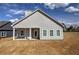 Back of home with large covered patio and ceiling fan, overlooking newly seeded lawn with some partial dirt at 203 Daisy Ne Ct, Cartersville, GA 30121