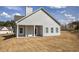 Back of home with large covered patio and ceiling fan, overlooking newly seeded lawn with some partial dirt at 203 Daisy Ne Ct, Cartersville, GA 30121