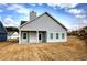 Back of home with large covered patio and ceiling fan, overlooking newly seeded lawn with some partial dirt at 203 Daisy Ne Ct, Cartersville, GA 30121