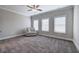 Cozy bedroom with chair, three windows, a ceiling fan, plush carpet, and neutral walls at 203 Daisy Ne Ct, Cartersville, GA 30121