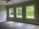 Bright bedroom featuring three windows, grey walls and vinyl plank flooring at 203 Daisy Ne Ct, Cartersville, GA 30121