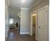 Hallway with wood floors and white doors leading to bathroom and an open view into the living room and fireplace at 203 Daisy Ne Ct, Cartersville, GA 30121