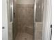 Modern tile shower with built-in seat and glass door featuring bronze hardware at 203 Daisy Ne Ct, Cartersville, GA 30121