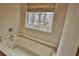 A bathroom featuring a soaking tub next to a window offering natural light and privacy at 402 Rising Cir, Woodstock, GA 30189