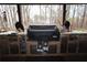 Outdoor kitchen featuring a built-in grill, sink, and granite countertops with wooded view at 402 Rising Cir, Woodstock, GA 30189