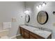 Bathroom with dark wood cabinets, granite countertop, double sink, and two mirrors at 5020 Puritan Dr, Sugar Hill, GA 30518