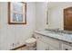 Cozy bathroom with wood-look wallpaper, granite countertop, and a wood framed window at 5020 Puritan Dr, Sugar Hill, GA 30518