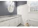 Bathroom featuring dark blue walls, a single sink vanity with a granite countertop, toilet, and a window at 5020 Puritan Dr, Sugar Hill, GA 30518