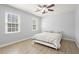 Bedroom with a ceiling fan, two windows and a bed with white and black patterned comforter at 5020 Puritan Dr, Sugar Hill, GA 30518