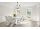 Dining room featuring a contemporary white table with seating for six and lots of natural light at 5020 Puritan Dr, Sugar Hill, GA 30518