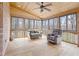 Comfortable sunroom featuring a ceiling fan, lots of natural light, and outdoor wooded views at 5020 Puritan Dr, Sugar Hill, GA 30518