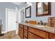 Main bathroom featuring double sinks, granite counters, and a closet at 9204 Malcolm Dr, Covington, GA 30014