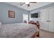 Bedroom featuring a queen bed, tv, light blue walls, and neutral carpet at 9204 Malcolm Dr, Covington, GA 30014