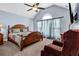 Vaulted main bedroom featuring a ceiling fan, large window, and comfortable seating area at 9204 Malcolm Dr, Covington, GA 30014