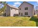 Home's backyard with green grass, a small patio and fence at 11961 Lovejoy Crossing Way, Hampton, GA 30228