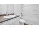 Well-lit bathroom showcasing a tub-shower combo, white cabinets, and dark countertops at 11961 Lovejoy Crossing Way, Hampton, GA 30228