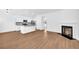 Open living space featuring a fireplace, wood floors, and a modern kitchen with stainless appliances at 11961 Lovejoy Crossing Way, Hampton, GA 30228