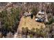 Expansive aerial view of a property with a house, barn, cleared land, and surrounding mature trees at 1537 David Lee St, Acworth, GA 30102