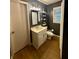 Dark painted bathroom with a white sink, new lighting fixture, wood floors, toilet and shelves at 1537 David Lee St, Acworth, GA 30102