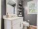 Gray bathroom with a white vanity, floating shelves, modern fixtures, and natural light at 1537 David Lee St, Acworth, GA 30102