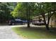 Exterior of a tan home featuring a deck, gravel driveway, and ample parking space at 1537 David Lee St, Acworth, GA 30102