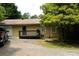 Tan single-story home with a deck and a gravel driveway, surrounded by mature trees at 1537 David Lee St, Acworth, GA 30102