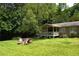 Relaxing outdoor space with firepit and chairs on a large lawn next to covered porch of ranch-style house at 1537 David Lee St, Acworth, GA 30102