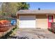View of detached garage with red door, white garage door, and items stored on side of the fence at 1537 David Lee St, Acworth, GA 30102