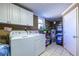 Bright laundry room with white appliances, cabinets, and a window, plus tiled floors and water heater at 1537 David Lee St, Acworth, GA 30102