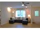 Bright living room featuring a large sectional sofa, ceiling fan, and natural light from the window at 1537 David Lee St, Acworth, GA 30102