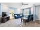 Comfortable living room with plush blue seating, a ceiling fan, and natural light at 1537 David Lee St, Acworth, GA 30102