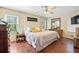 Bright main bedroom featuring hardwood floors, a ceiling fan, and sun-lit windows for a warm, inviting feel at 1537 David Lee St, Acworth, GA 30102
