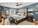 Beautiful bedroom with a large bed with gray cushioned headboard and a ceiling fan at 1820 N Creek Cir, Alpharetta, GA 30009