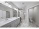 Bright bathroom featuring a double sink vanity and frameless shower with marble-style tile at 185 Bellehaven Dr, Woodstock, GA 30188