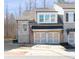 Charming townhome exterior showcases a two-car garage, stone accents, and well-maintained landscaping at 185 Bellehaven Dr, Woodstock, GA 30188