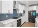 Well-equipped kitchen showcases white cabinets, stainless steel appliances, and stylish backsplash at 185 Bellehaven Dr, Woodstock, GA 30188