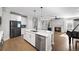Open-concept kitchen featuring white cabinets, stainless steel appliances, and a view of the living area at 185 Bellehaven Dr, Woodstock, GA 30188