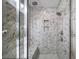 Walk-in shower featuring marble-style herringbone tile, shower bench, and two shower heads at 185 Bellehaven Dr, Woodstock, GA 30188
