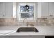 Close-up on a stainless sink, stone countertop and backsplash, and window in bright kitchen at 2524 Columbia Crossing Ct, Decatur, GA 30034