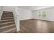 Open-concept living space boasting wood-look floors and a staircase at 1213 Arnhem Dr, Hampton, GA 30228