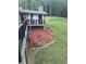Landscaped backyard with a mulched area, lush greenery, and a view of the home's outdoor structure at 1655 Butler Bridge Rd, Covington, GA 30016