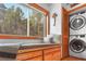 Convenient laundry room with stacked washer and dryer, plus a cozy window bench for relaxation at 1655 Butler Bridge Rd, Covington, GA 30016