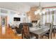 Open-concept living and dining area with a stone fireplace, large windows, and a dining table at 1655 Butler Bridge Rd, Covington, GA 30016