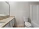 Bathroom showcasing a vanity with solid surface top, toilet, and white tiled shower/tub at 2070 Charles Cudd Ct, Lithonia, GA 30058