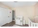 Bedroom featuring a baby changing table, a crib with pink bedding, and a closet for storing baby essentials at 7760 Poppy Dr, Winston, GA 30187