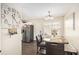 Dining area with decorative clock, stainless steel refrigerator, and wooden table set for dining at 7760 Poppy Dr, Winston, GA 30187