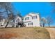 Two-story home with light siding, dark trim, and a large front yard on a sunny day at 7760 Poppy Dr, Winston, GA 30187