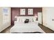 Stylish main bedroom showcases a plum accent wall and a well-coordinated bedroom set at 7760 Poppy Dr, Winston, GA 30187