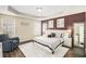 A spacious main bedroom with tray ceilings, two windows, and decorative plum accent wall at 7760 Poppy Dr, Winston, GA 30187